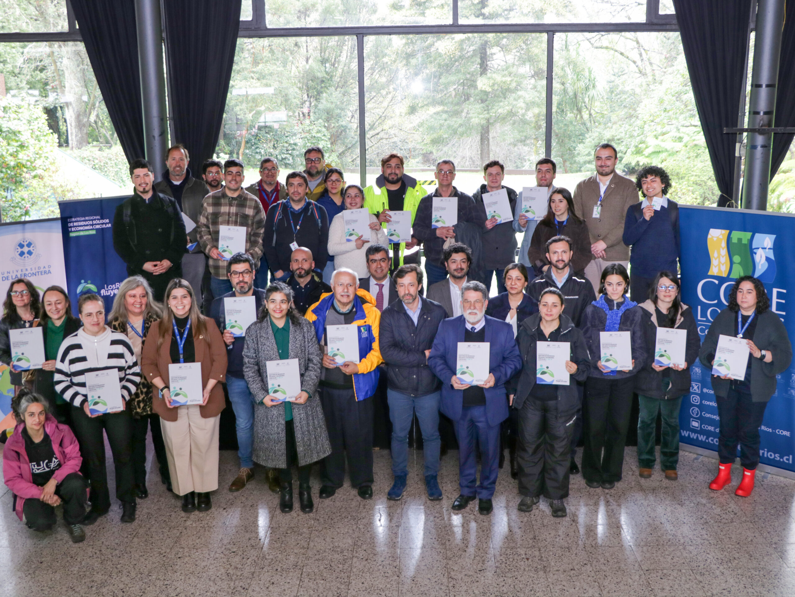 Grupo de personas posando con documentos en una ceremonia de la Estrategia Regional de Residuos Sólidos en Los Ríos