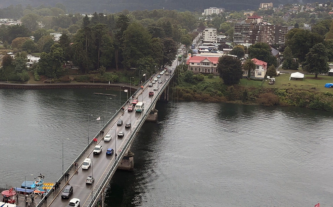 Vista elevada de un puente con tráfico vehicular cruzando un río en un día nublado