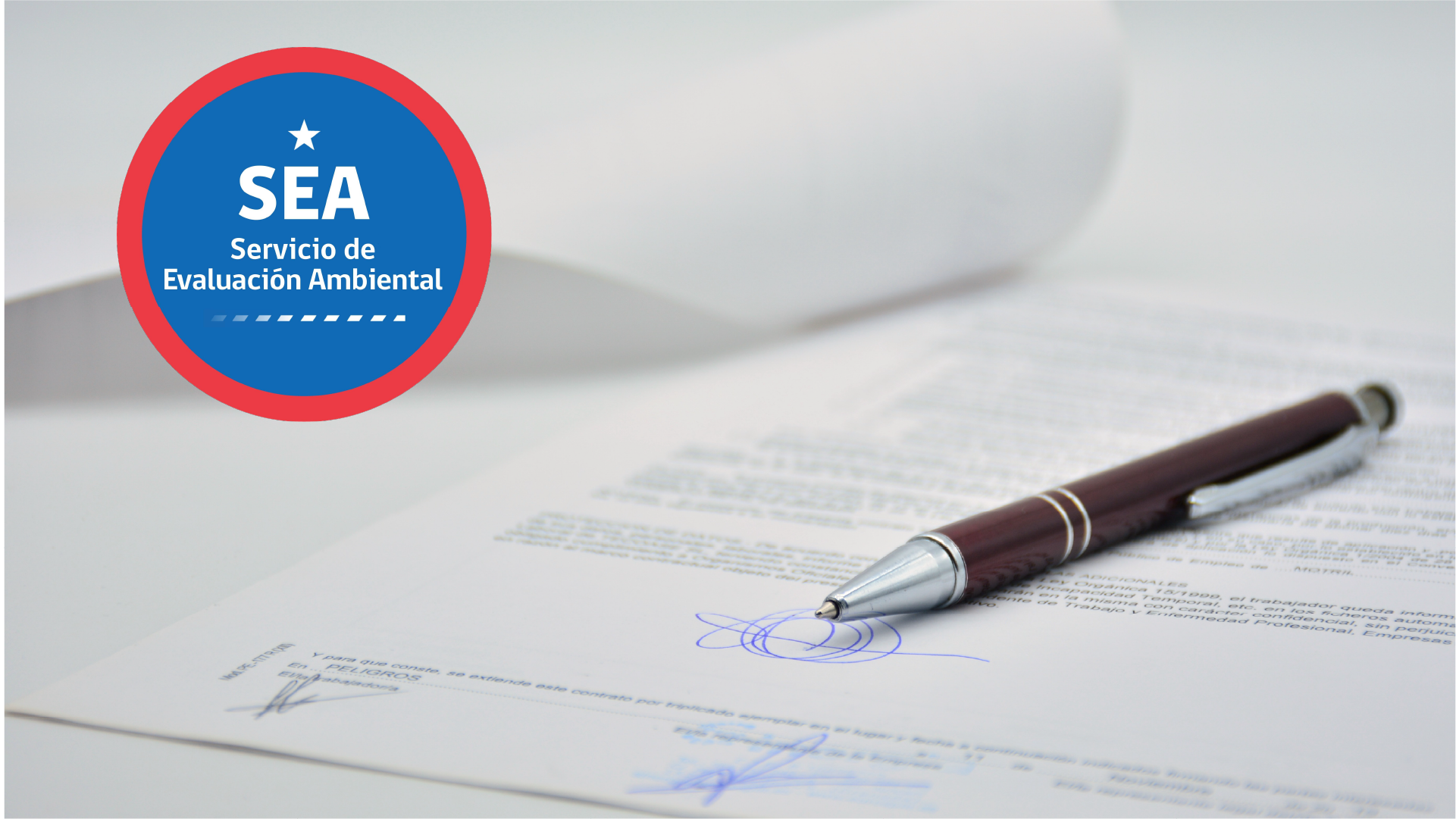 Logo del Servicio de Evaluación Ambiental junto a documentos y un bolígrafo sobre una firma.
