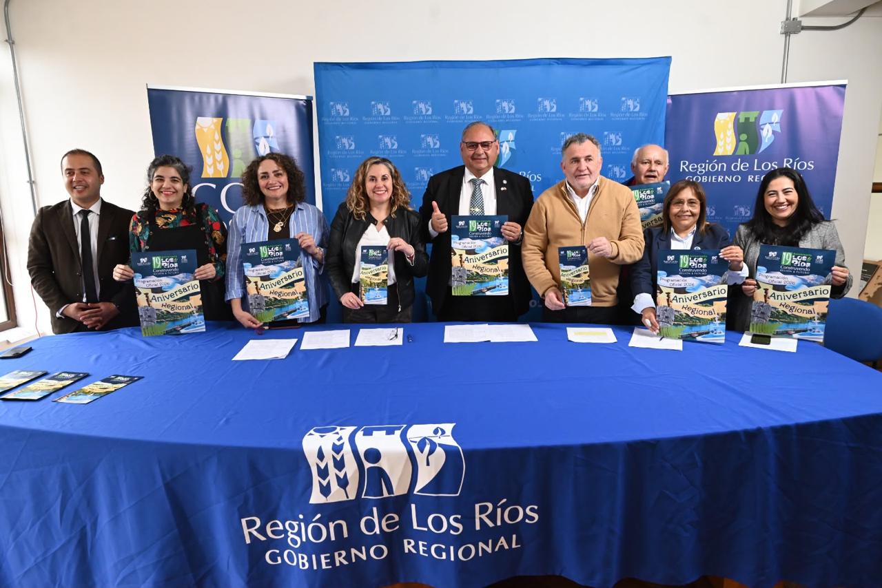Autoridades del Gobierno Regional de Los Ríos mostrando folletos del programa del Aniversario Regional