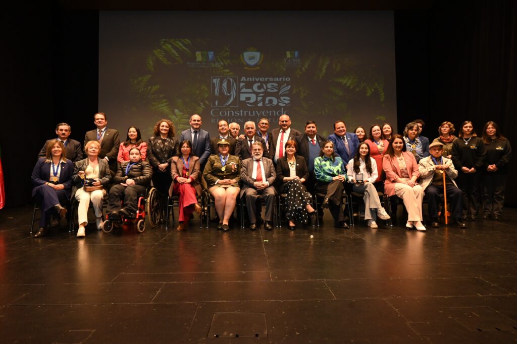 Autoridades y homenajeados posan en el escenario durante la celebración del 16.° aniversario de la Región de Los Ríos