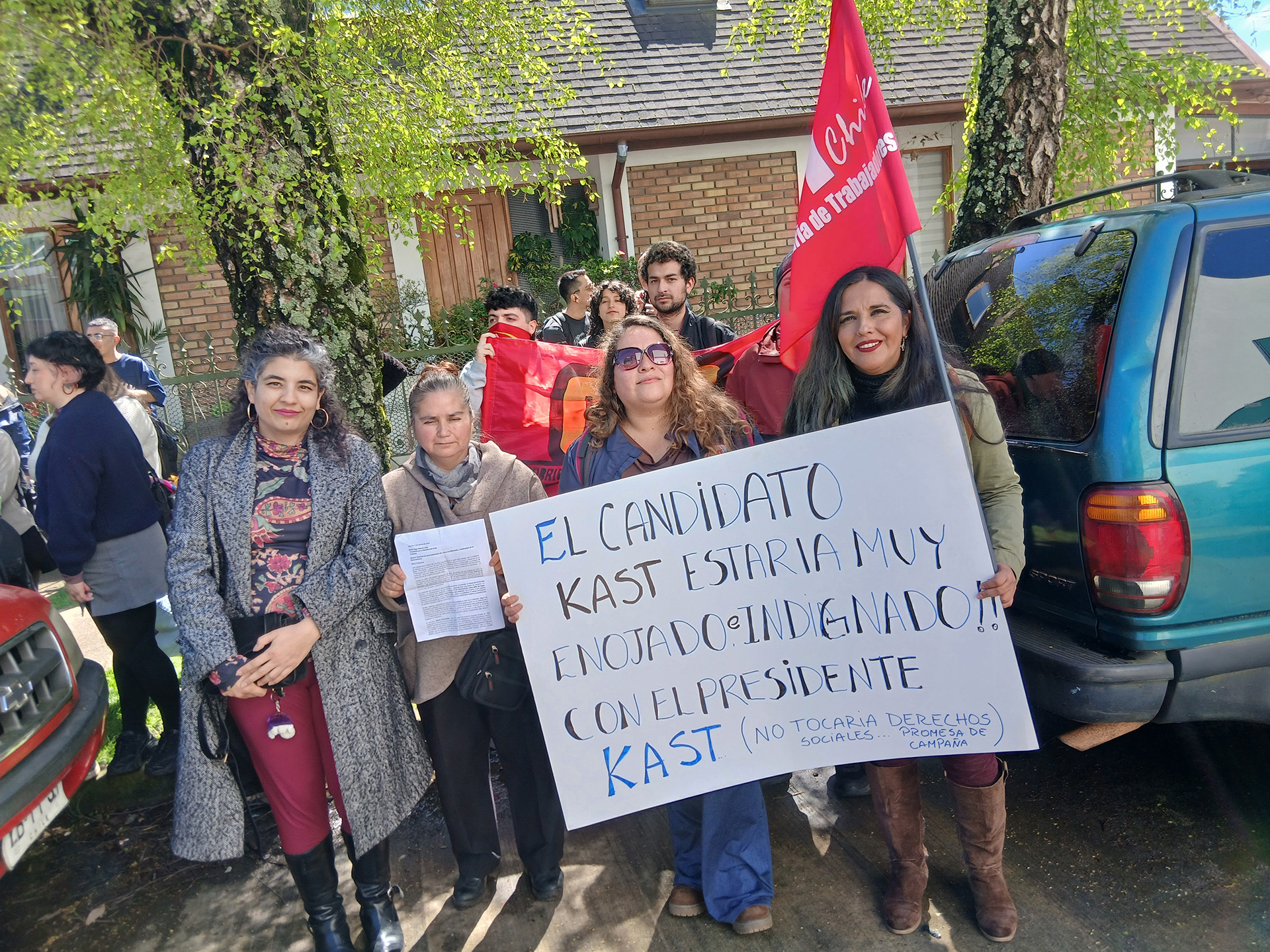 Grupo de manifestantes sosteniendo un cartel que dice: El candidato Kast estaría muy enojado e indignado con el presidente Kast